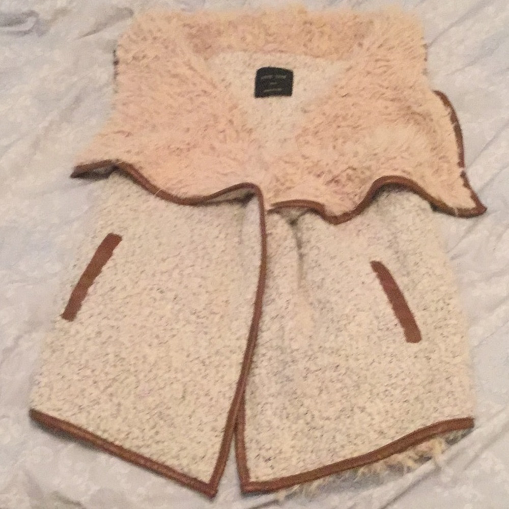 Tan colored  collar with brown leather trim vest